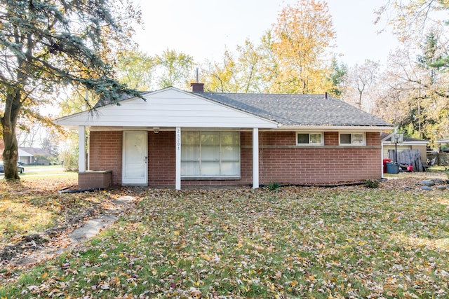 rear view of property featuring a yard