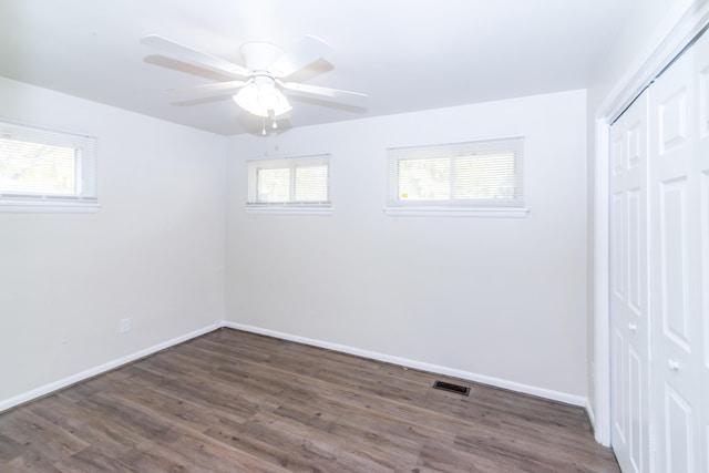 unfurnished bedroom featuring a closet, ceiling fan, and dark wood-type flooring