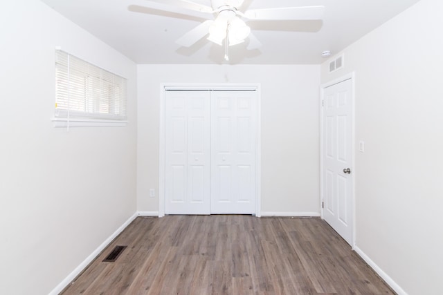 unfurnished bedroom featuring ceiling fan, wood-type flooring, and a closet