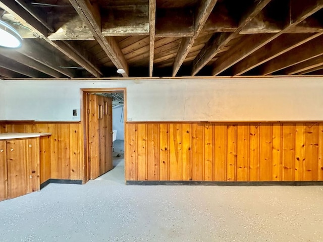 basement featuring wood walls