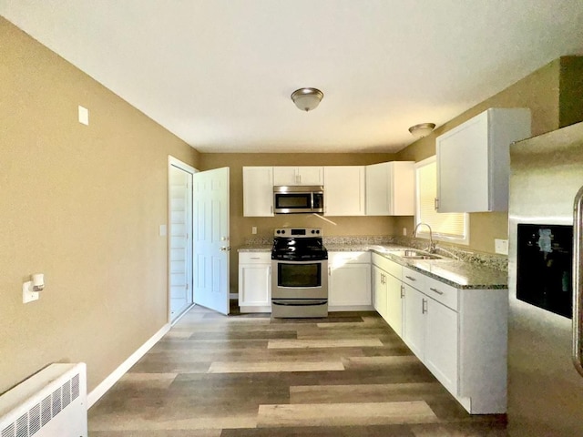 kitchen with white cabinets, sink, appliances with stainless steel finishes, and dark wood-type flooring