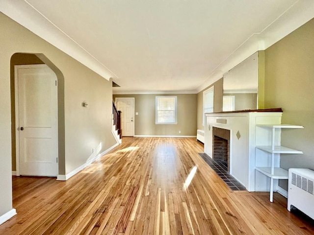 unfurnished living room with radiator heating unit and light hardwood / wood-style floors