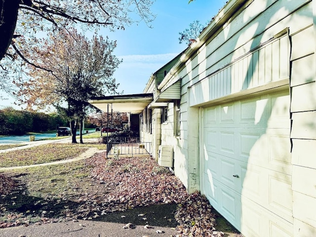 view of side of home with covered porch and a garage