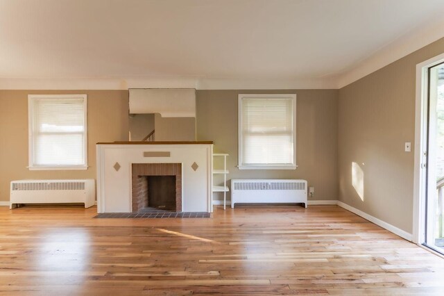 unfurnished living room with radiator heating unit and a healthy amount of sunlight