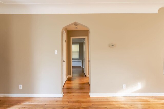 hall with radiator heating unit and wood-type flooring