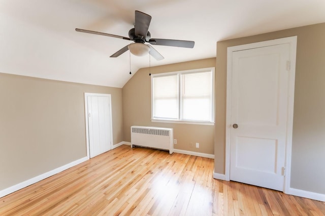 bonus room with light hardwood / wood-style flooring, radiator, lofted ceiling, and ceiling fan