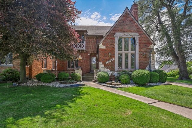 tudor-style house featuring a front yard