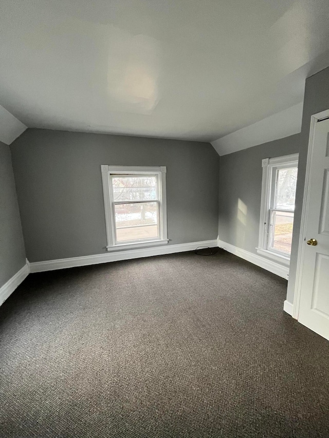 bonus room featuring dark colored carpet and vaulted ceiling