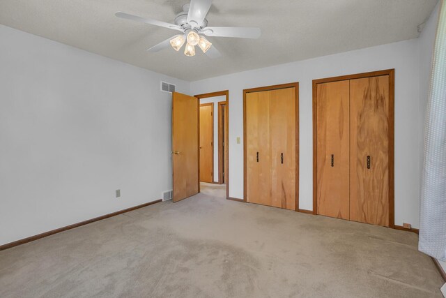 190 Steves Scenic Dr, Horton, MI 49246 - unfurnished bedroom with two closets, carpet floors, baseboards, and ceiling fan