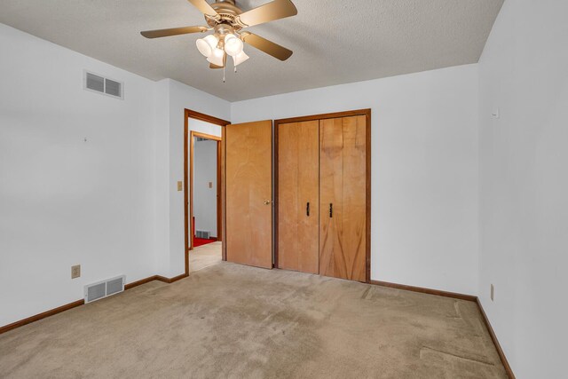 190 Steves Scenic Dr, Horton, MI 49246 - unfurnished bedroom featuring light carpet, baseboards, a textured ceiling, ceiling fan, and a closet
