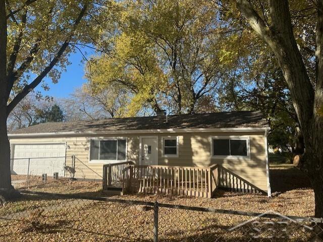 ranch-style house with a wooden deck and a garage