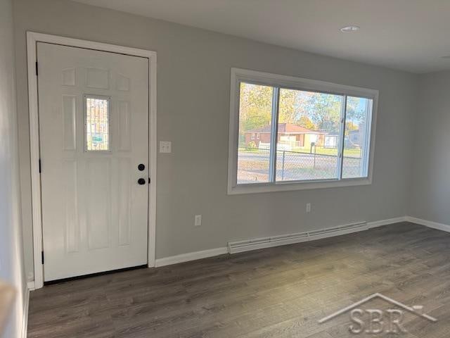 foyer with baseboard heating and dark wood-type flooring