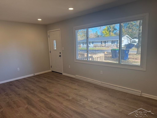 foyer entrance with a baseboard radiator and dark hardwood / wood-style floors