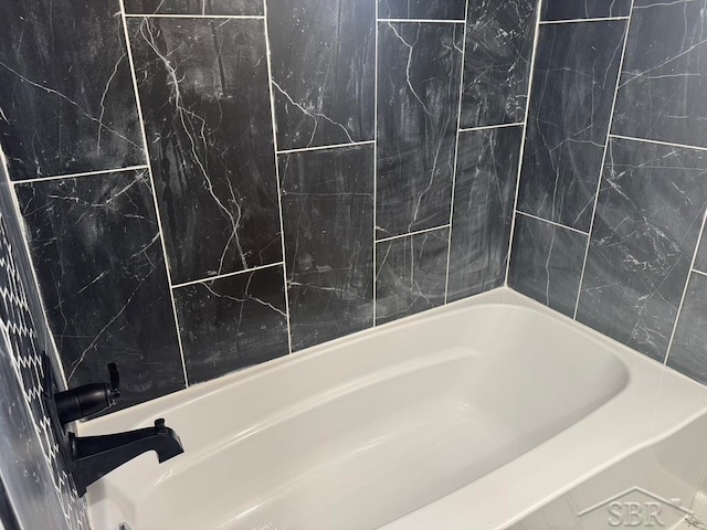 bathroom with tile walls and tiled shower / bath