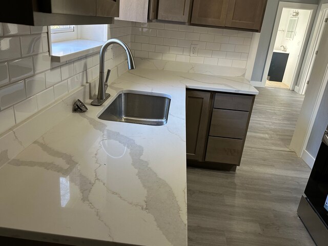 54 Nelson St, Pontiac, MI 48342 - kitchen featuring a sink, backsplash, light stone counters, and wood finished floors
