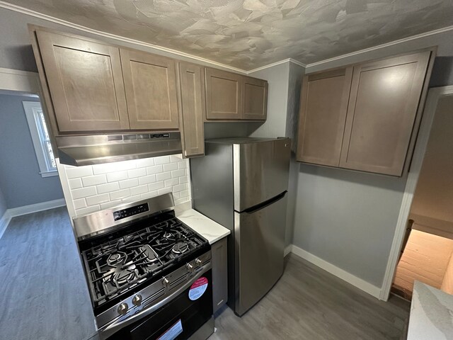 54 Nelson St, Pontiac, MI 48342 - kitchen featuring stainless steel appliances, under cabinet range hood, tasteful backsplash, and wood finished floors