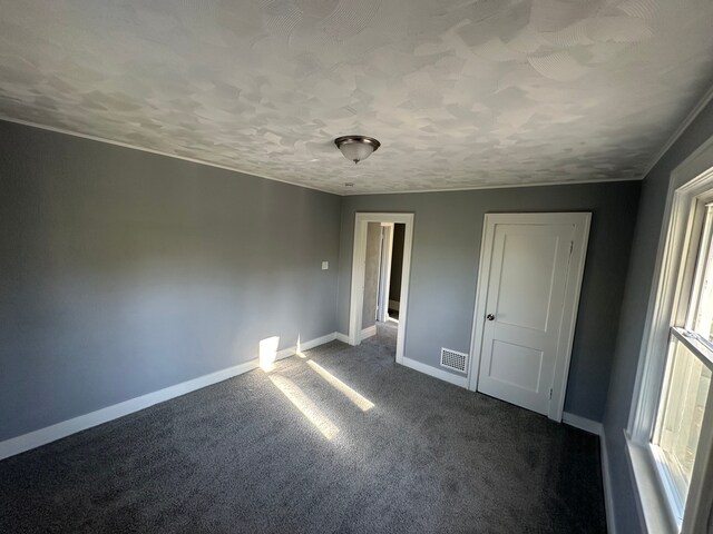 54 Nelson St, Pontiac, MI 48342 - unfurnished room featuring baseboards, dark colored carpet, and a textured ceiling