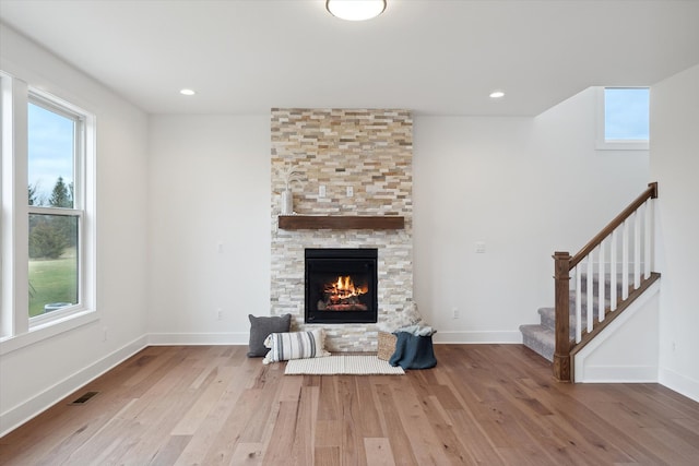 living room with hardwood / wood-style flooring, a fireplace, and a wealth of natural light