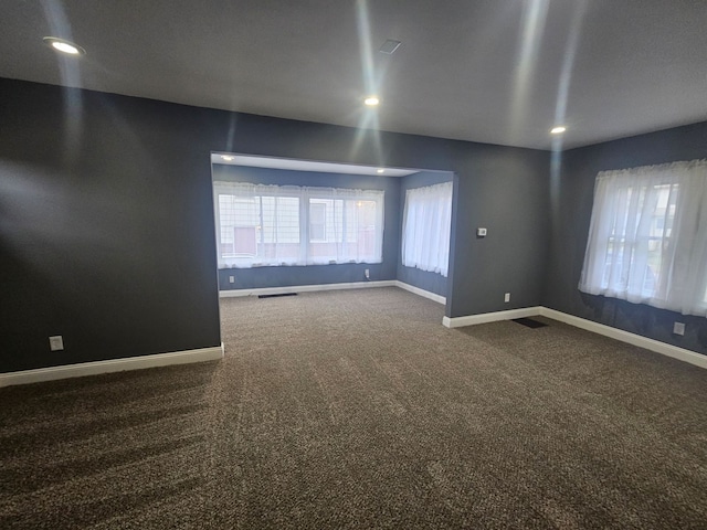 carpeted spare room featuring a healthy amount of sunlight