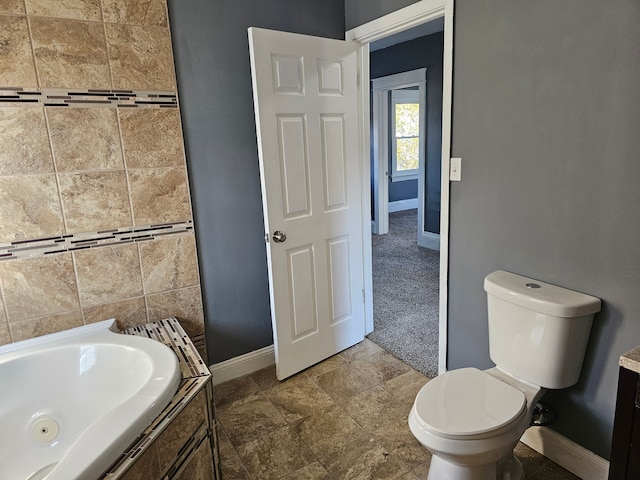 bathroom with toilet, sink, and tiled tub