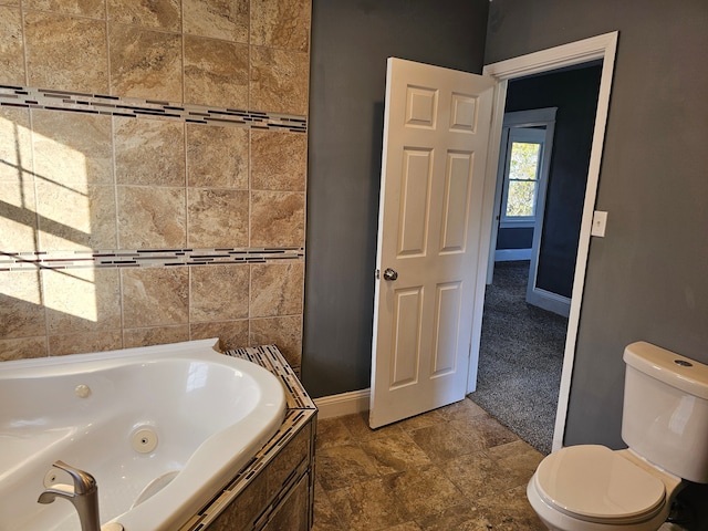 bathroom with a relaxing tiled tub and toilet