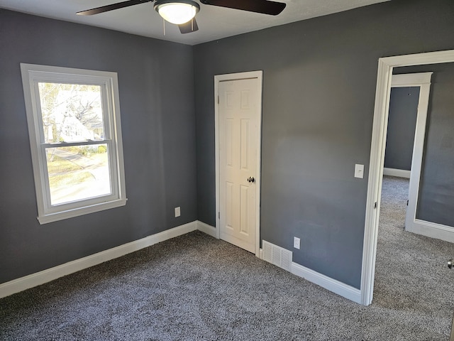 unfurnished bedroom featuring dark colored carpet and ceiling fan