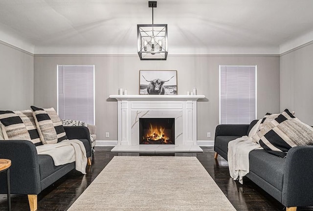 living room with a high end fireplace and dark wood-type flooring