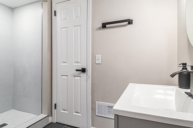 bathroom featuring vanity and tiled shower