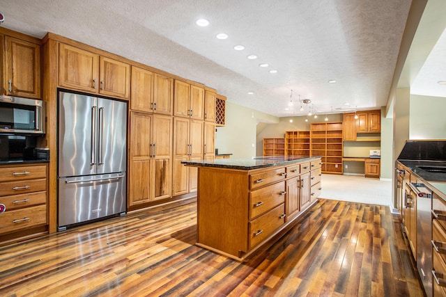 16460 15 Mile Rd, Marshall, MI 49068 - kitchen featuring stainless steel appliances, dark wood-style flooring, a textured ceiling, brown cabinets, and a center island