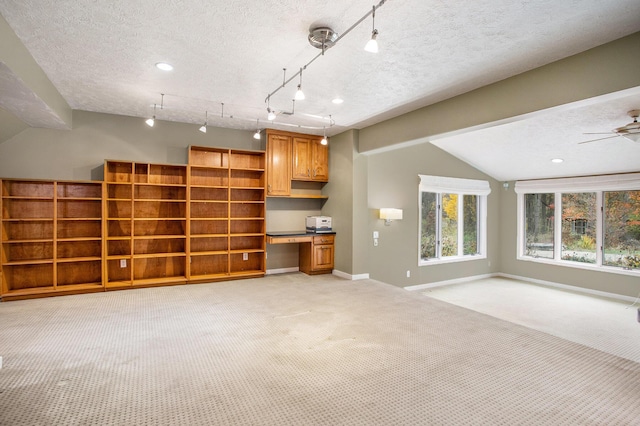 16460 15 Mile Rd, Marshall, MI 49068 - unfurnished living room with vaulted ceiling, light carpet, built in desk, a textured ceiling, and ceiling fan