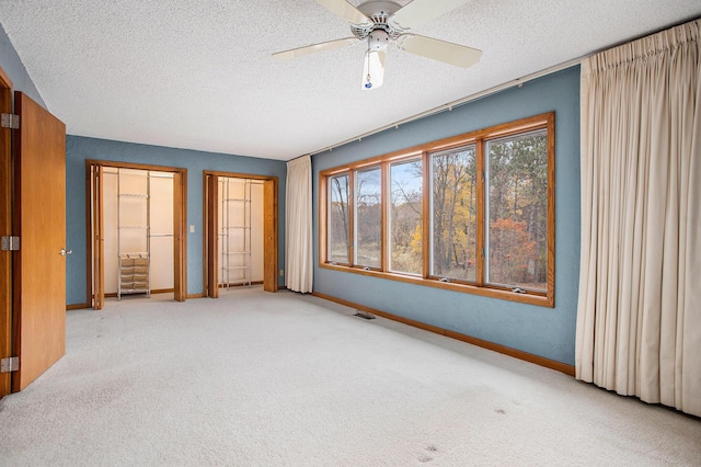 16460 15 Mile Rd, Marshall, MI 49068 - unfurnished bedroom featuring carpet, a textured ceiling, two closets, and ceiling fan