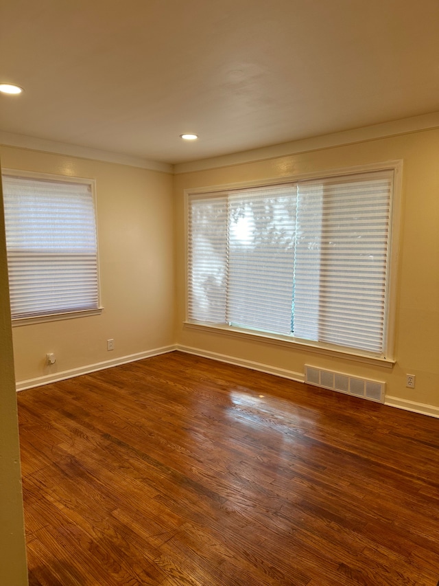 empty room featuring dark hardwood / wood-style floors and crown molding