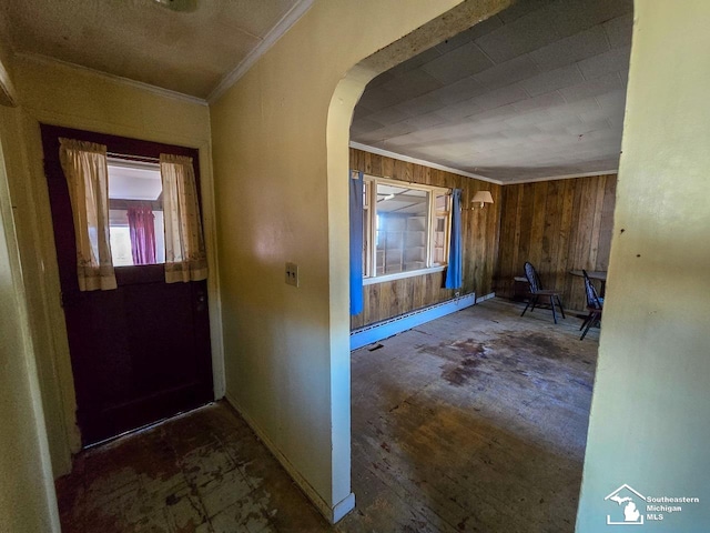 entryway featuring wooden walls, baseboard heating, and ornamental molding