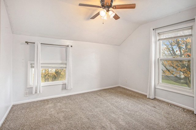 additional living space with carpet floors, a healthy amount of sunlight, and lofted ceiling