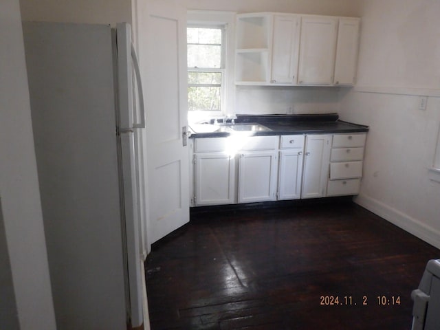124 W Maple St, Kalamazoo, MI 49001 - kitchen featuring freestanding refrigerator, dark countertops, open shelves, white cabinetry, and dark wood-type flooring