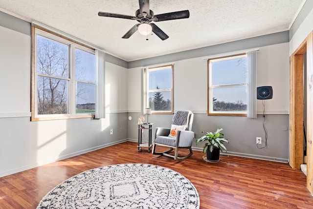 living area featuring wood-type flooring, a textured ceiling, plenty of natural light, and ceiling fan