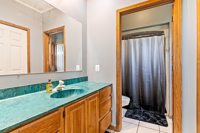 bathroom with tile patterned flooring, vanity, toilet, and walk in shower