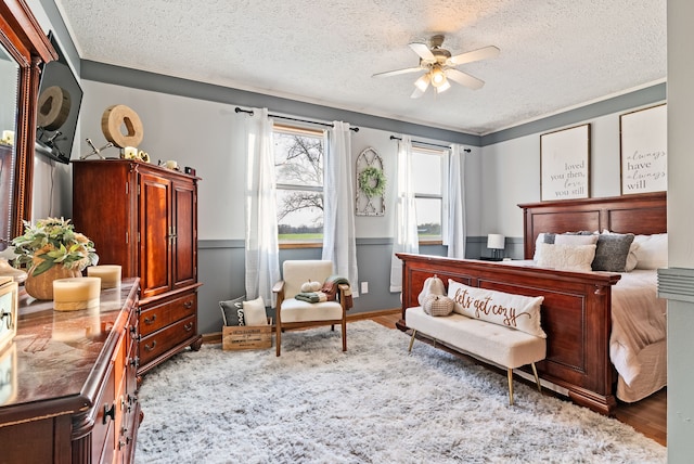 bedroom featuring ceiling fan, light hardwood / wood-style floors, and a textured ceiling