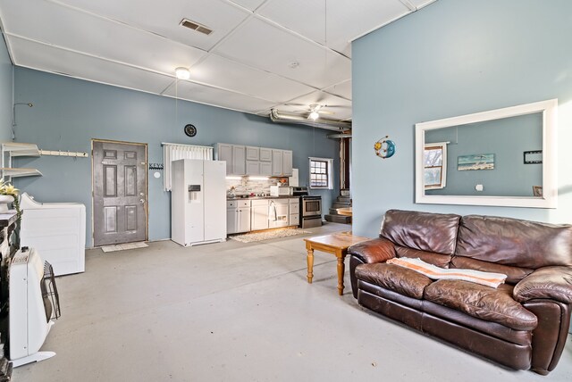 living room with ceiling fan and washer / dryer