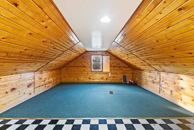 bonus room featuring lofted ceiling, carpet floors, and wooden walls