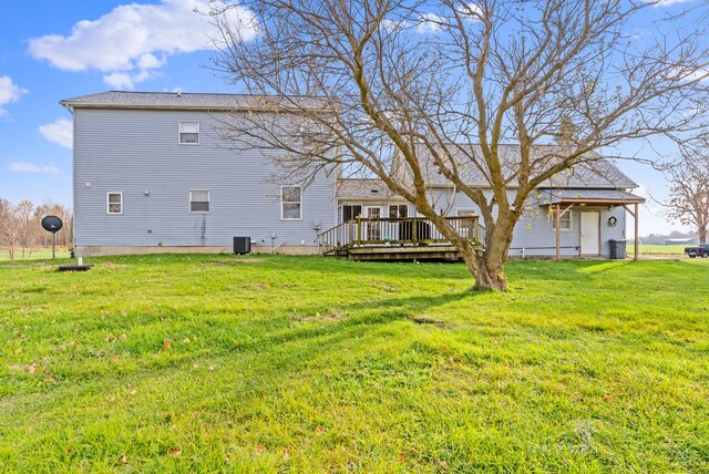 back of property featuring central air condition unit, a wooden deck, and a yard