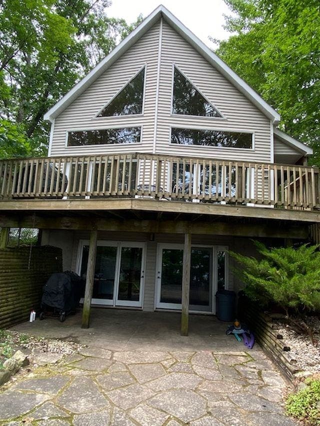 rear view of property with a wooden deck and a patio area