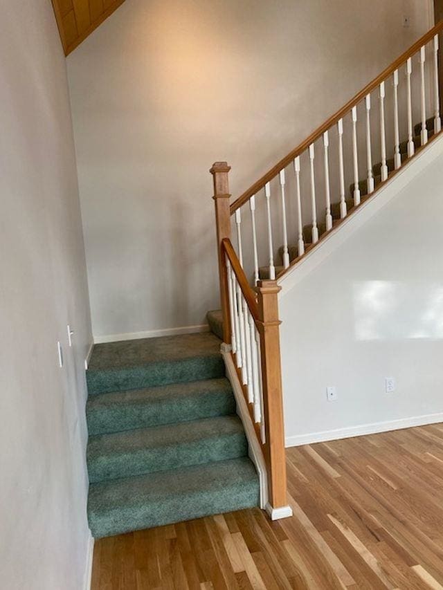 stairs with lofted ceiling and wood-type flooring