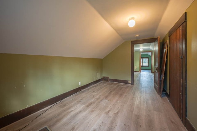 bonus room with light hardwood / wood-style flooring and lofted ceiling