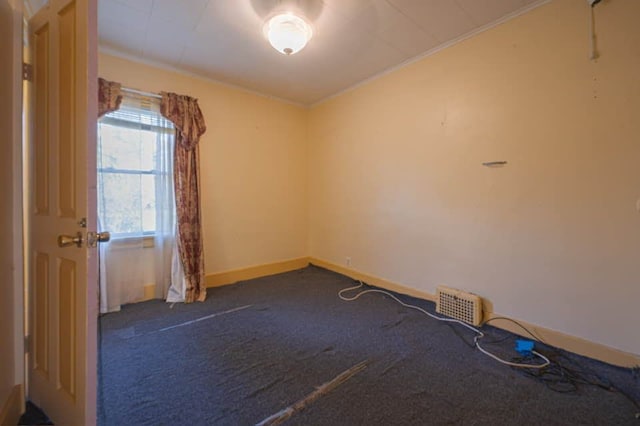 spare room featuring dark carpet and ornamental molding