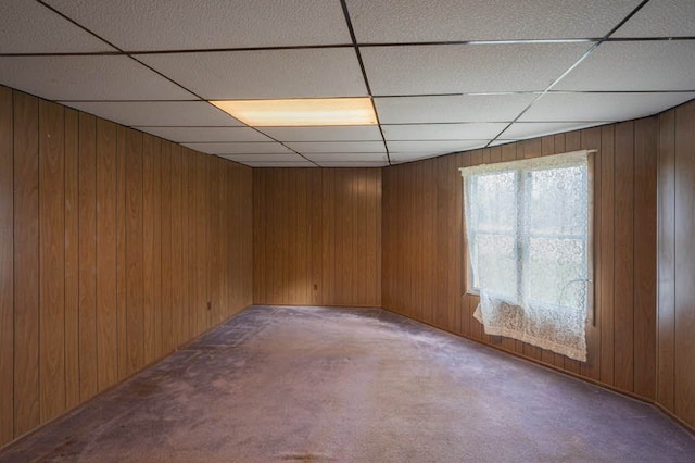 unfurnished room with carpet flooring and wood walls