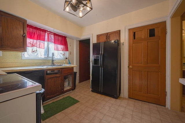 kitchen featuring range, sink, and black refrigerator with ice dispenser