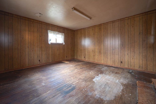 empty room featuring dark hardwood / wood-style floors and wood walls