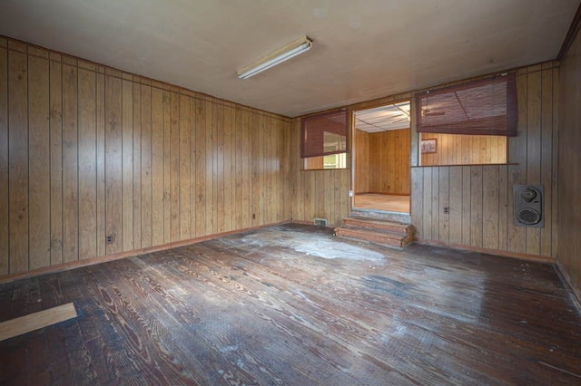 unfurnished room with dark hardwood / wood-style floors and wood walls