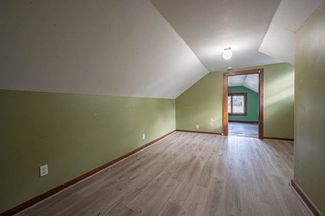 additional living space with lofted ceiling and light wood-type flooring